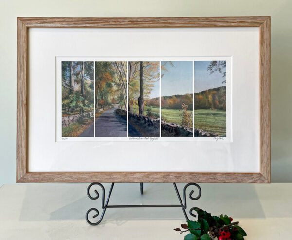 A framed print of a road with trees in the background.