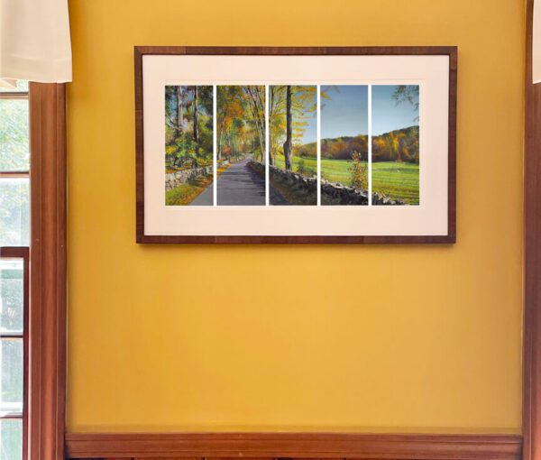 A framed photo of Autumn, River Road, small print in a combed wooden frame 12.5 x 18.5 x 2-inches in a room with yellow walls.