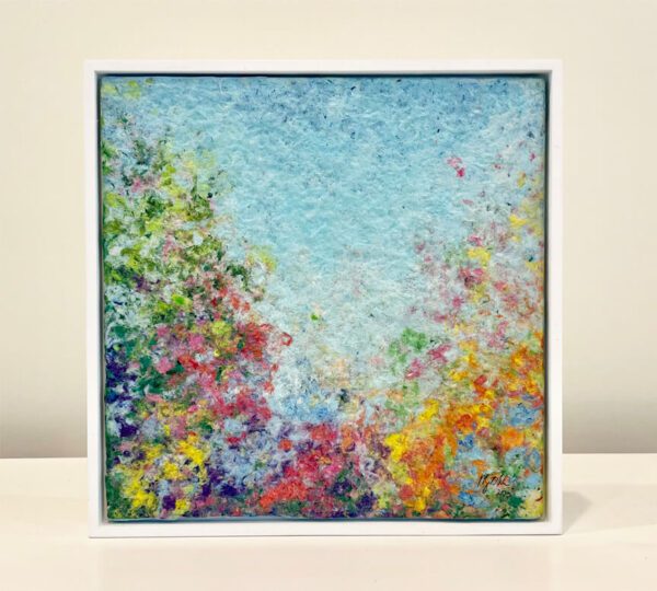A painting of colorful flowers in a white frame.