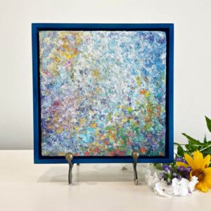 An abstract painting in a blue frame with flowers.