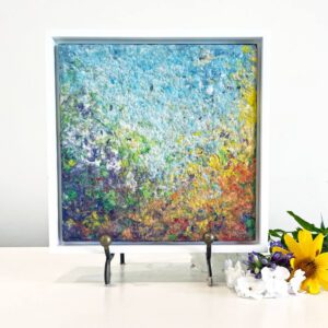 A white frame with a colorful painting on it.