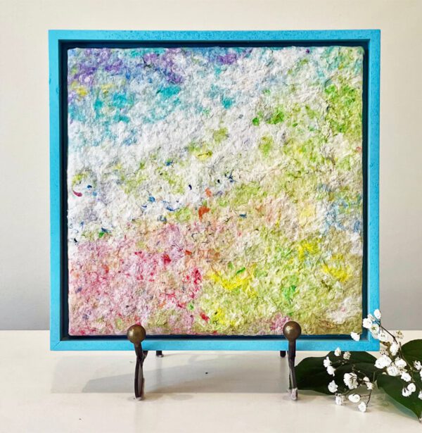 A blue frame with a colorful painting on it.