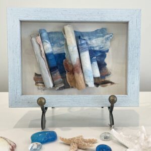 A blue frame with sea shells and a starfish.