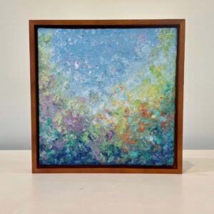 An abstract painting in a wooden frame.