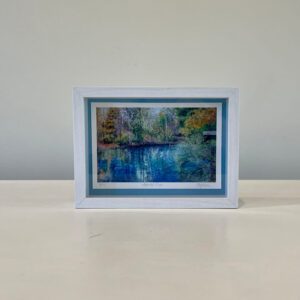 A picture of a lake in a white frame.