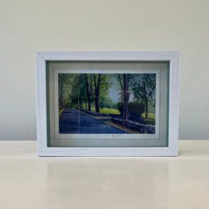 A white frame with a picture of a park.