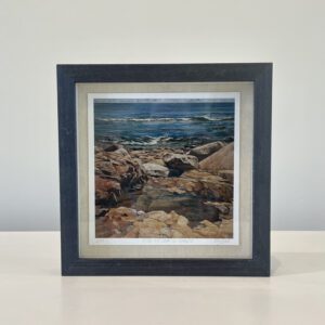 A black frame with a picture of a rocky shore.