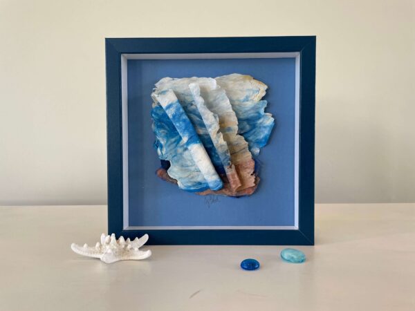 A framed piece of seashells and a blue frame.