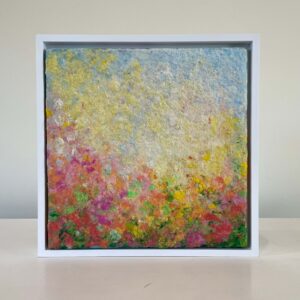 A framed abstract painting featuring a blend of vibrant colored textures resembling a flower garden, displayed against a plain background.