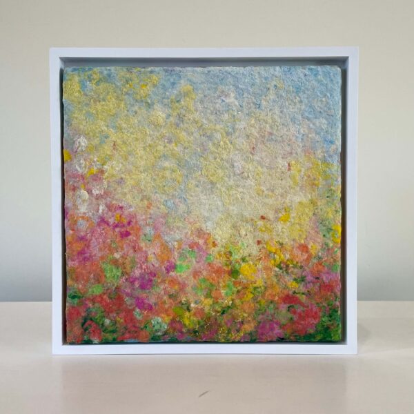 A framed abstract painting featuring a blend of vibrant colored textures resembling a flower garden, displayed against a plain background.