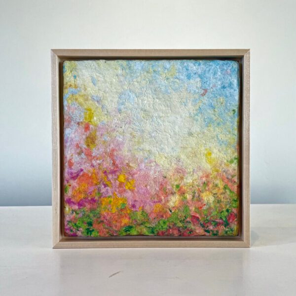 A colorful abstract painting with pastel hues displayed in a wooden frame on a white background.