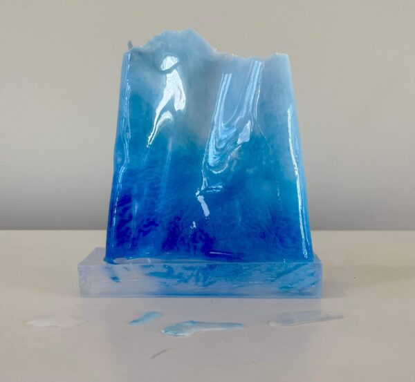 A translucent blue resin sculpture resembling icy peaks, displayed against a neutral background.