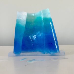 A transparent blue gradient resin sculpture with textures resembling ice, displayed against a plain white background.