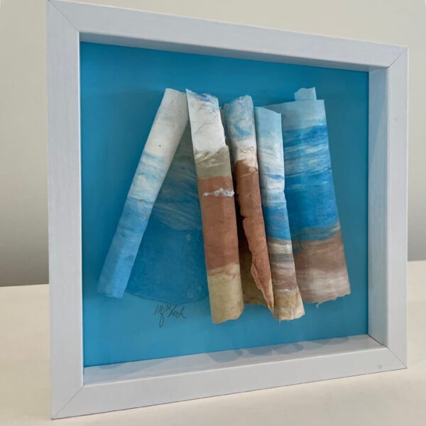 Framed abstract paper art with blue and brown tones.