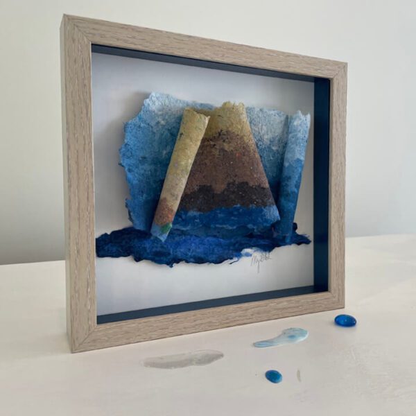 Framed abstract art with blue and brown paper.