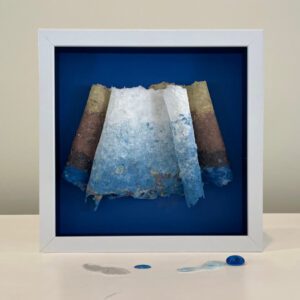 Framed abstract paper sculpture in blue hues.