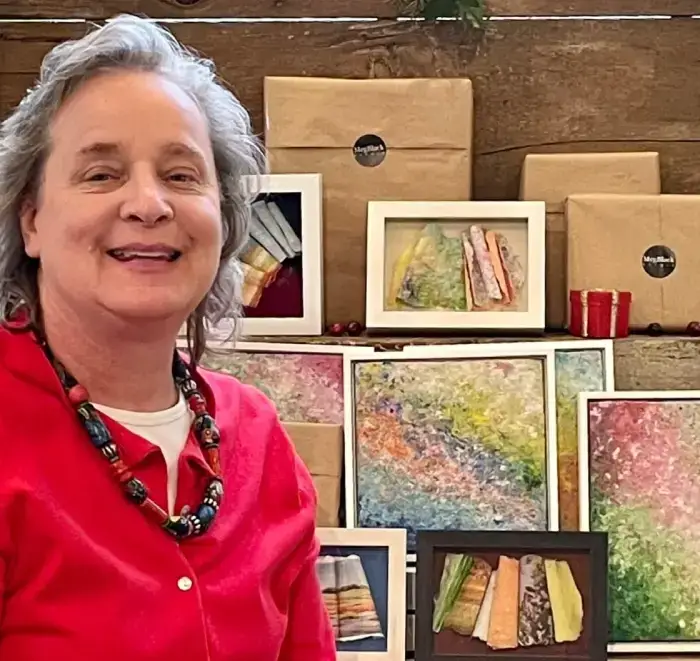 A woman standing in front of a display of art.