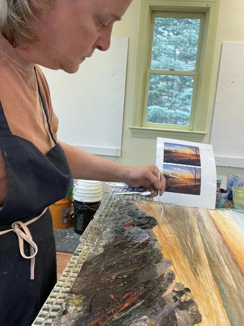 A woman working on a painting.
